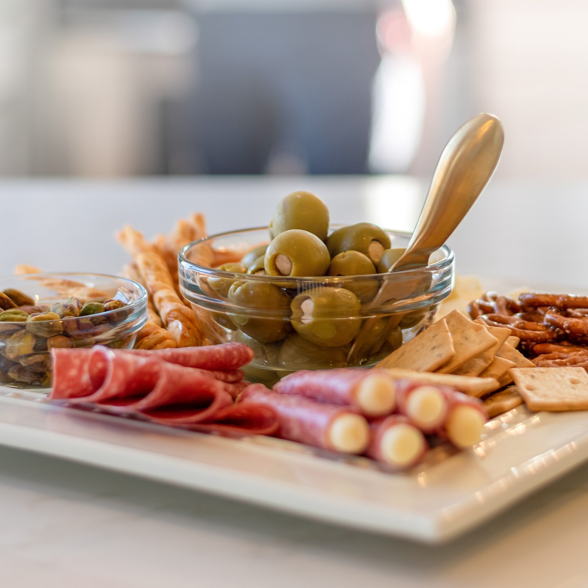 A beautifully arranged charcuterie board showcasing meats, cheeses, and Vodka Garlic Tipsy Olives, perfect for entertaining.